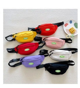 Flat lay of colorful children's canvas waist bags with PEACE patches in seven vibrant colors