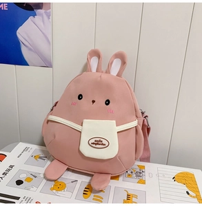 Detail of pink cartoon rabbit crossbody bag with soft fabric ears and shoulder strap