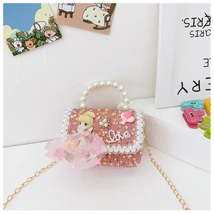 Detail of pink sequin girl's purse with pearl handle and cartoon doll ornament