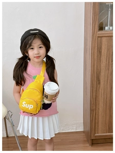 Close-up of yellow canvas kids chest bag featuring white text with adjustable shoulder strap