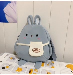 Detail of grey-blue rabbit canvas bag showing 3D ears, embroidery, and front white pocket