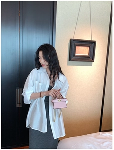 Mini borsa a mano rosa in pelle con chiusura a scatto dorata e tracolla a catena su modella