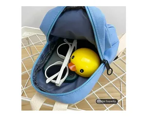 Macro shot of sky blue canvas mini backpack showing inner capacity for toys and glasses
