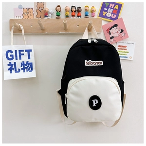 Detail of contrast color canvas backpack for kids featuring embroidered lettering and zipper pocket