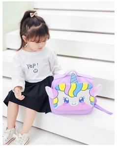 Toddler girl wearing a purple unicorn backpack with 3D ears on white stairs