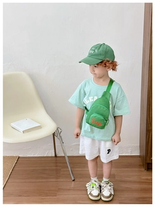 Detail of neon green canvas kids chest bag with orange Sup text and nylon texture