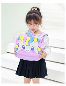 Toddler girl holding a cute purple unicorn canvas backpack on white stairs