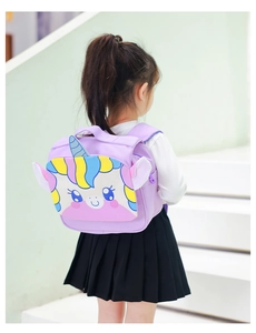 Toddler girl wearing a purple unicorn canvas backpack with 3D ears on a staircase