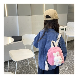 Detailed back view of a pink canvas toddler backpack with a 3D plush bunny and straps