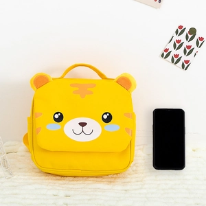 Detail view of cartoon tiger toddler backpack with cute ears on white plush rug