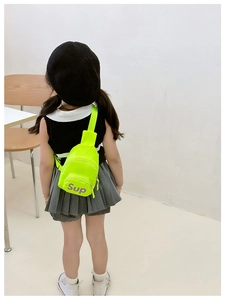 Detail of neon green canvas kids chest bag featuring purple Sup letter print on front