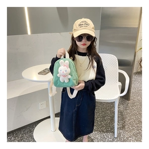 Detail of green canvas toddler backpack featuring a cute 3D plush bunny with pink bow
