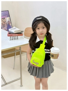 Detailed view of kids neon green canvas chest bag with Sup logo worn by a young girl