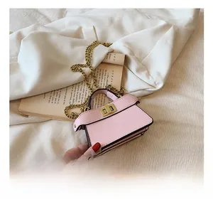 Dettaglio della mini borsa rosa chiaro con chiusura girevole dorata e tracolla a catena