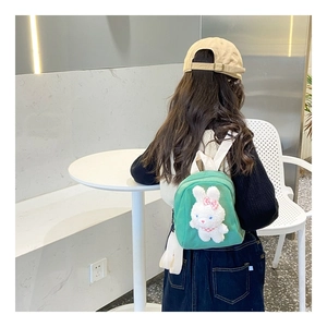 Detail of cute plush bunny on green canvas toddler backpack with adjustable straps