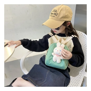 Detail view of green canvas kids backpack with a cute 3D bunny plush and adjustable straps