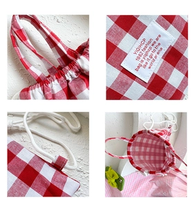 Detail view of red and white checkered canvas mini backpack with drawstring and woven label