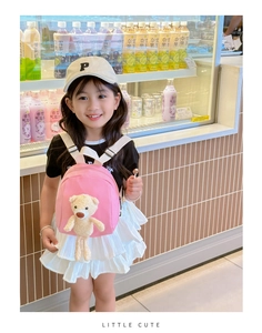 Close-up of pink canvas mini backpack for kids with cute plush 3D teddy bear charm