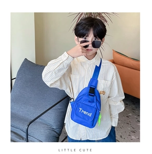 Detail of blue canvas kids chest bag with Trend lettering and adjustable strap