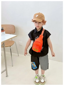 Detail showing kids bright orange canvas chest bag with green Sup letter printing
