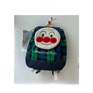 Close-up of green checkered kids backpack with cartoon character and embroidery detail