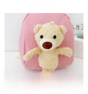 Detailed view of pink canvas backpack featuring a 3D plush bear doll decoration