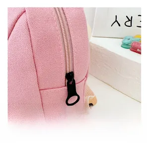 Close-up of smooth black plastic zipper on pink canvas kids mini backpack fabric