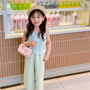 Cute girl's mini pearl handbag in pink sequins paired with a stylish mint green outfit