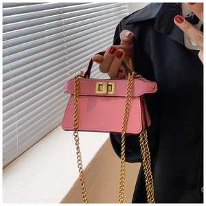 Dettaglio mini borsa rosa con tracolla a catena dorata e chiusura a girello in metallo