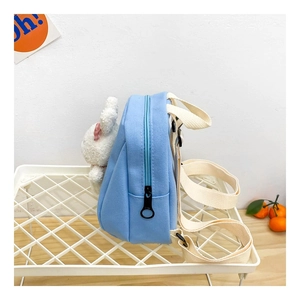 Detail view of light blue canvas kids backpack with a cute plush bunny on the side