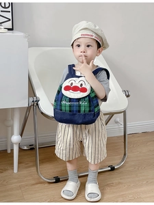 Detail of canvas kids backpack with cartoon embroidery and blue green checkered design