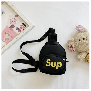 Detail view of a black nylon kids chest bag with yellow lettering and cute accessories