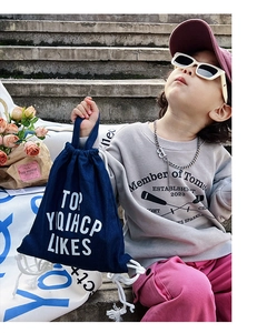 Detail view of navy blue canvas drawstring bag with white bold typography for kids