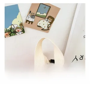 Close-up of the thick beige canvas top handle on a cute pink mini kids backpack