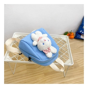 Detail of blue canvas kids backpack featuring 3D plush rabbit and smooth zipper closure