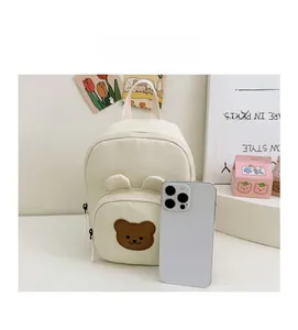 Mini sac à dos en toile avec ours et téléphone pour comparer les dimensions