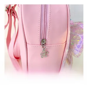 Détail du sac à dos rose en PU avec fermeture éclair fleurie et aile de papillon à paillettes