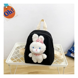 Detailed view of kids black canvas backpack with a plush white bunny and cream straps