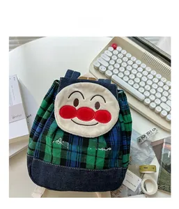 Detailed view of kids backpack featuring cartoon patchwork embroidery and plaid pattern