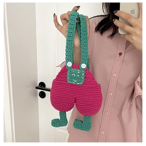Detail of handmade crochet overall bag in pink and green with white button accents