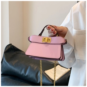 Dettaglio mini borsa in pelle rosa con tracolla a catena dorata e chiusura a girello