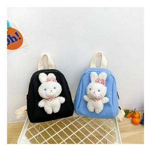Close-up of children's canvas backpacks with cute plush bunny decor in black and light blue