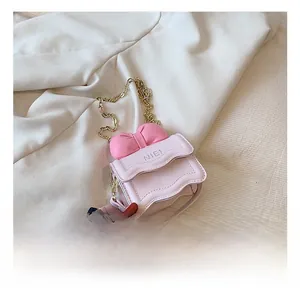 Détail du mini sac bandoulière rose avec un grand nœud et une chaîne dorée