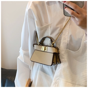 Selfie allo specchio con mini borsa in pelle crema con catena dorata e chiusura a scatto