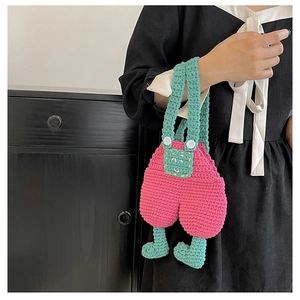 Detailed knit texture and denim overall design of a handmade crochet crossbody bag