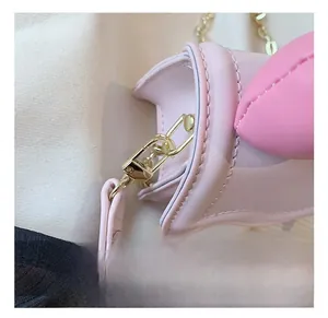 Détail du crochet en métal doré et des coutures sur un sac à bandoulière en cuir rose