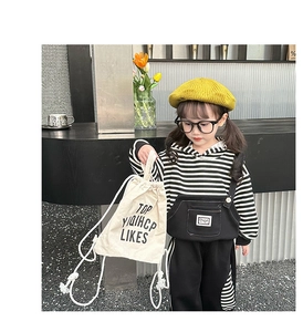 Detail of a kids cream canvas drawstring bag with black text for outdoor snacks