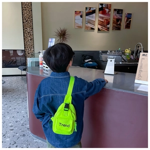 Kids neon green chest bag with Trend logo worn by a child in a casual setting