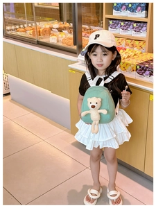 Detail shot of light green canvas toddler backpack featuring a 3D plush bear mascot