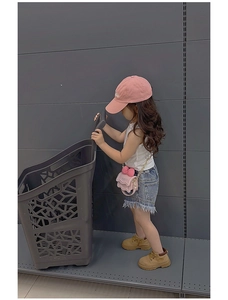 Vue détaillée du petit sac bandoulière rose pour enfant avec nœud et chaîne sur mannequin